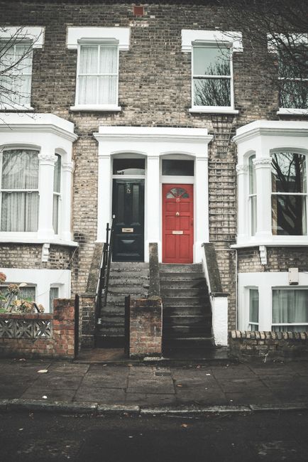 Exterior view of Victorian-style terraced houses in Haringey featuring ornate bay windows with white framing, sash windows with grille designs, and brick and stone façade details. The buildings are p